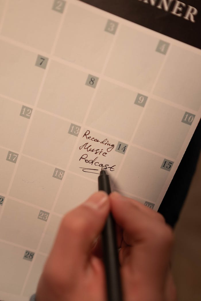 services-03 Close-up of a hand writing podcast recording date on a calendar. Ideal for content planning concepts.
